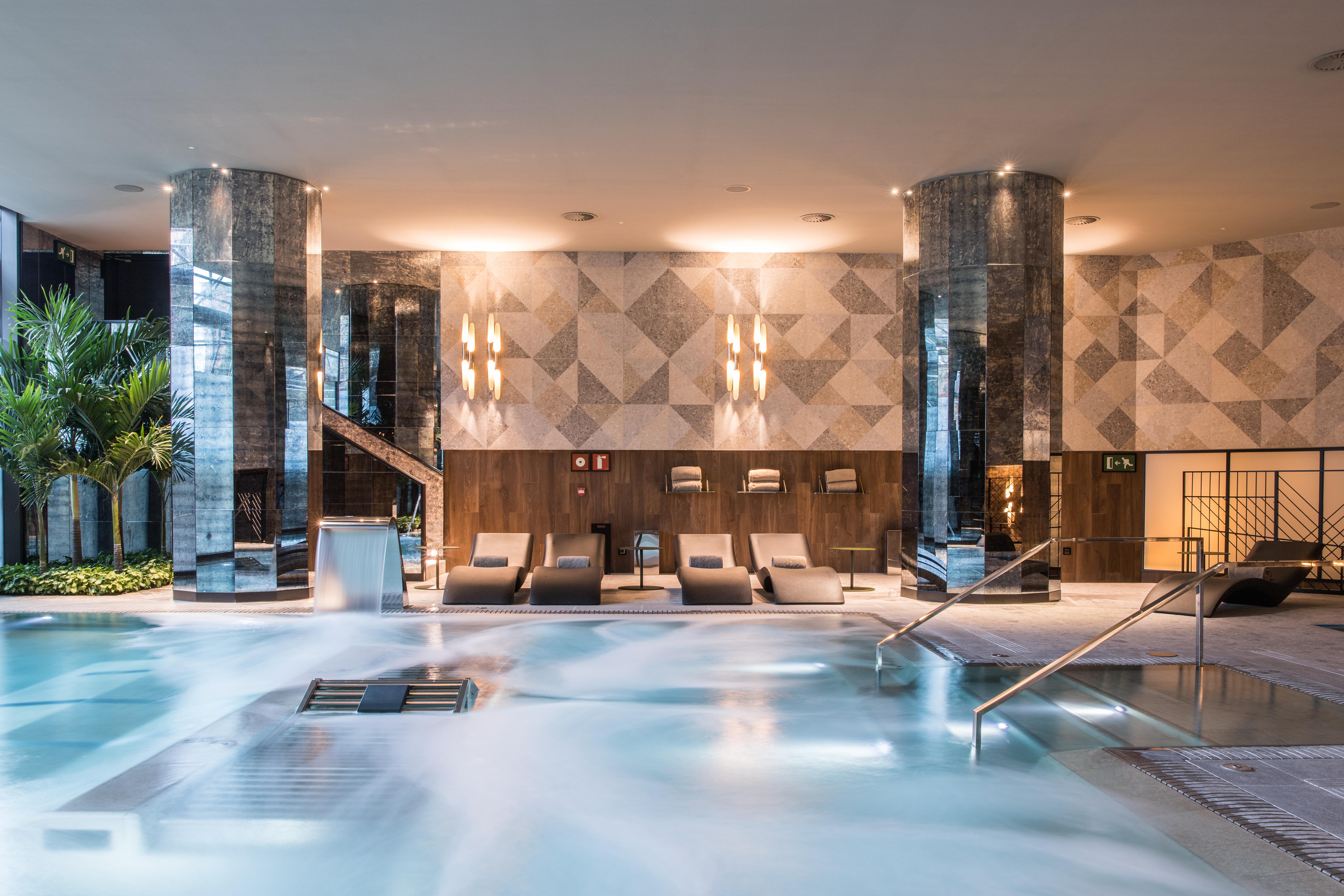 호텔 소피아 바르셀로나 - 인 더 언바운드 컬렉션 바이 하얏트 외부 사진 The photo shows a sophisticated spa area featuring a large, inviting pool with a calm, relaxing atmosphere. The pool area is surrounded by elegant columns and has a modern design. There are comfortable lounge chairs positioned nearby, and the lightin